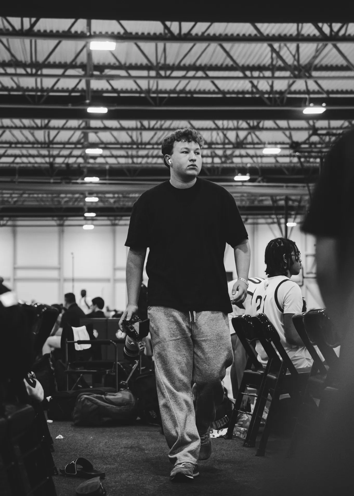 Bobby Matlock walks the sideline with his camera at a basketball event